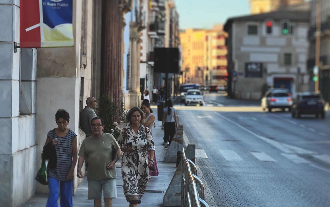 Vecinos paseando junto a un edificio histórico